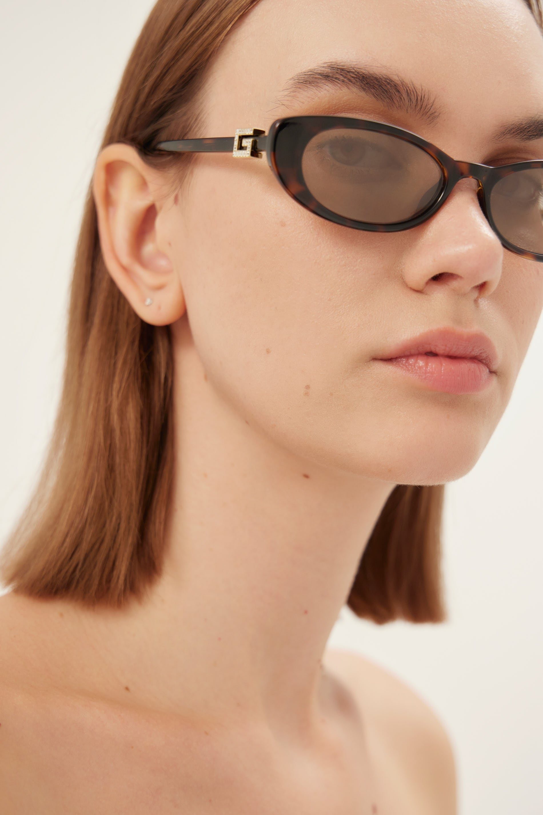Oval cat-eye brown and grey Gucci sunglasses with gold logo